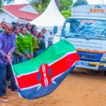MP Machua Waithaka stands with students as the SEPU truck delivers mobile lab equipment.