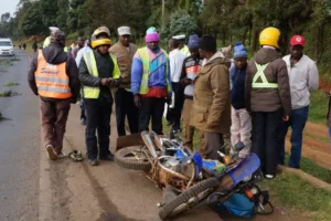 Boda Boda riders and Lari residents watch a wreckage of a motorcycle that was involved in an accident at Kwa Mathore area along the Nairobi Nakuru highway.