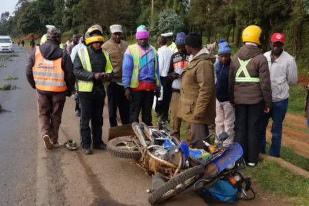 Boda Boda riders and Lari residents watch a wreckage of a motorcycle that was involved in an accident at Kwa Mathore area along the Nairobi Nakuru highway.