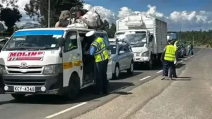 A traffic police officer from Lari police station inspecting a Public Service Vehicle on Christmas day at Nyambari area along the Nairobi Nakuru highway.